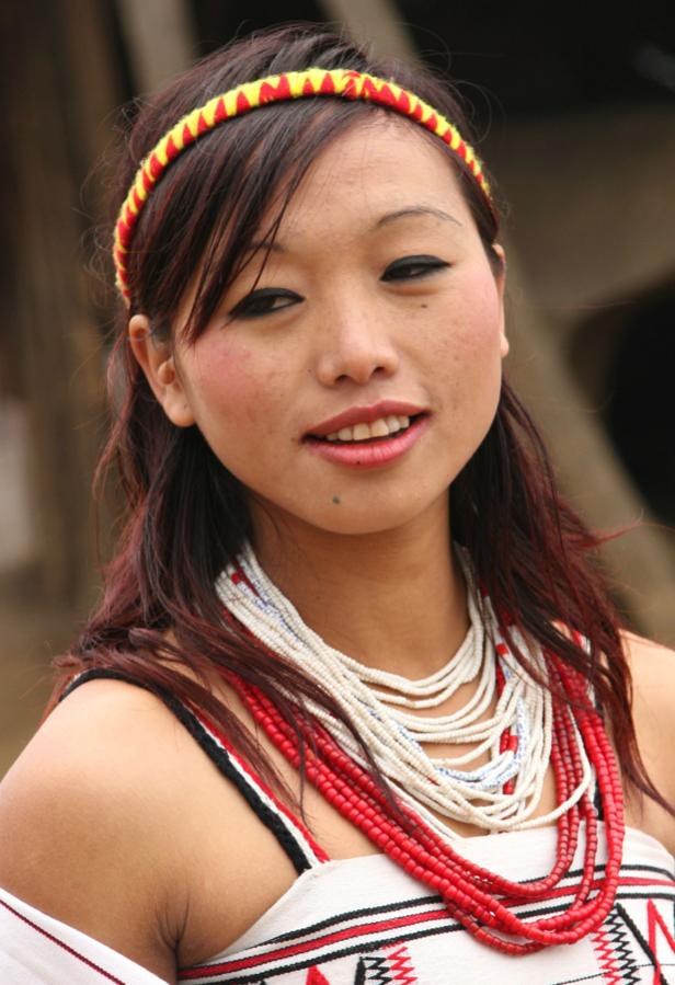 Eine junge Frau mit traditionellem Kopfschmuck und Halsketten der Naga in Indien.