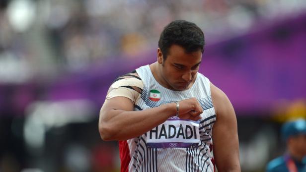 Ein Diskuswerfer, Hadadi, mit iranischer Flagge auf seinem Trikot, blickt konzentriert nach unten.