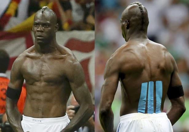 Mario Balotelli, ein Fußballspieler mit Kinesio-Tape auf dem Rücken, steht auf dem Spielfeld.