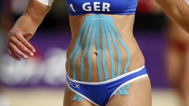 Der Bauch einer Beachvolleyballerin mit blauem Kinesio-Tape.