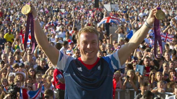 Sir Chris Hoy feiert mit zwei Goldmedaillen vor einer jubelnden Menschenmenge.