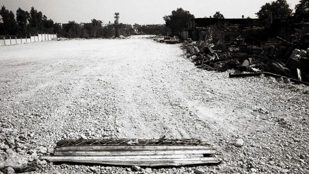 Eine monochrome Aufnahme einer Baustelle mit Schutt und Baumaterialien.