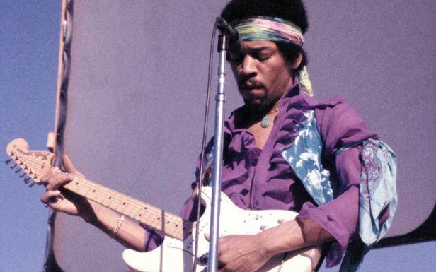 Jimi Hendrix spielt Gitarre während eines Auftritts.