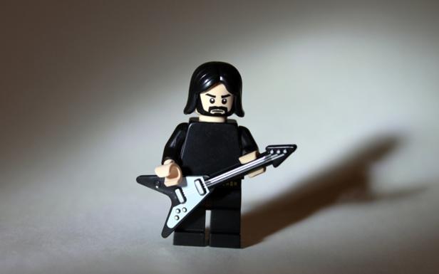 Eine Lego-Figur mit einer Gitarre in der Hand.