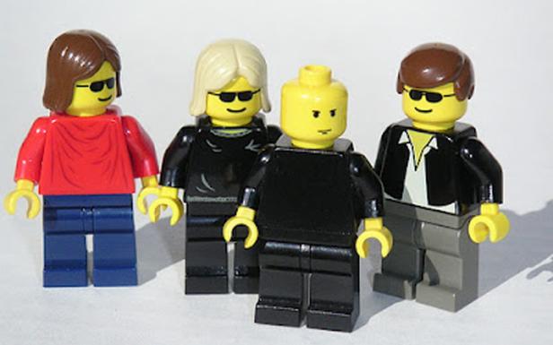 Vier Lego-Figuren mit Sonnenbrillen stehen nebeneinander.