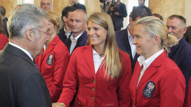 Heinz Fischer schüttelt Athletinnen in roten Jacken die Hand.