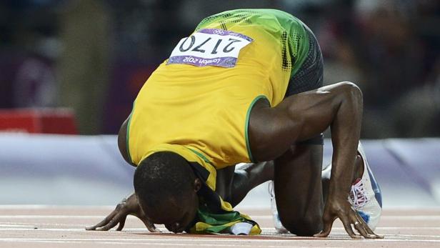 Usain Bolt kniet nach einem Rennen auf der Bahn.