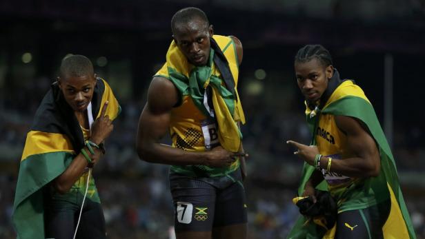 Usain Bolt und andere jamaikanische Sprinter feiern mit der jamaikanischen Flagge.