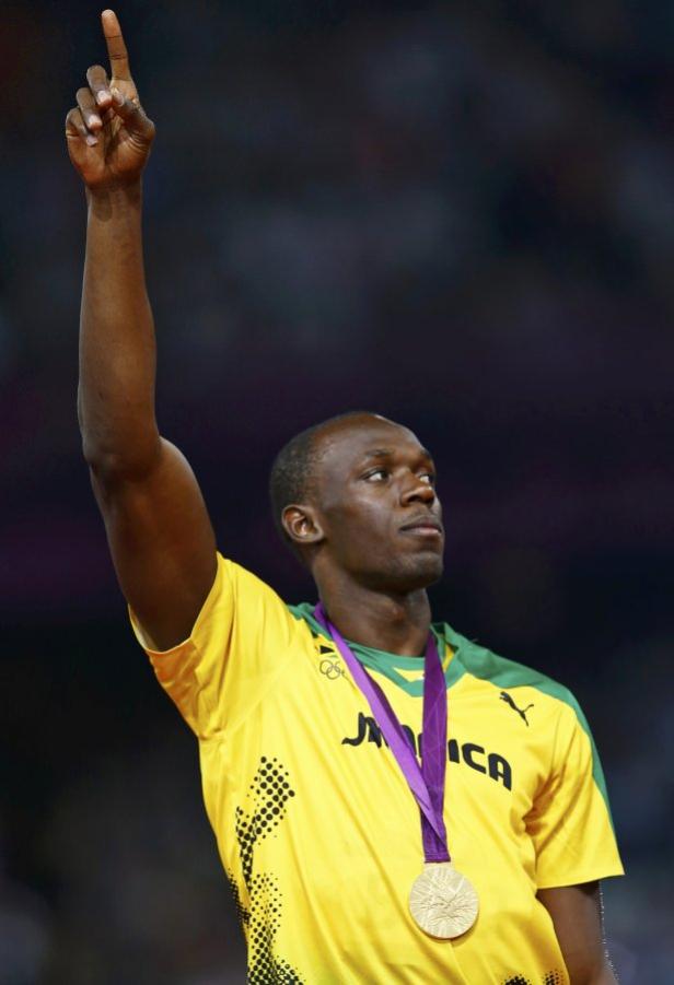 Usain Bolt feiert mit einer Goldmedaille und erhobenem Zeigefinger.