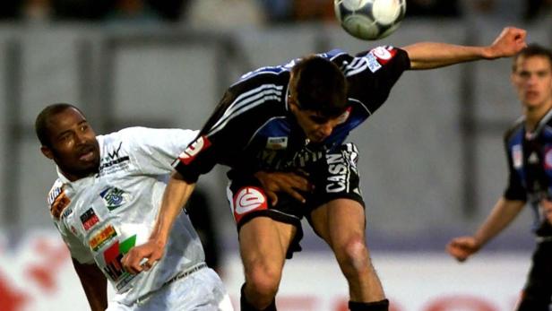 Zwei Fußballspieler kämpfen um den Ball während eines Spiels.