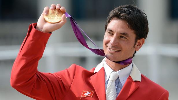 Steve Guerdat, ein Schweizer Springreiter, hält seine Goldmedaille der Olympischen Spiele London 2012 hoch.