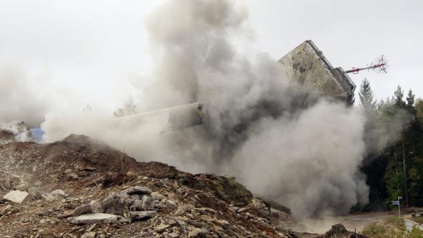 Eine große Staubwolke steigt bei einer Sprengung auf.