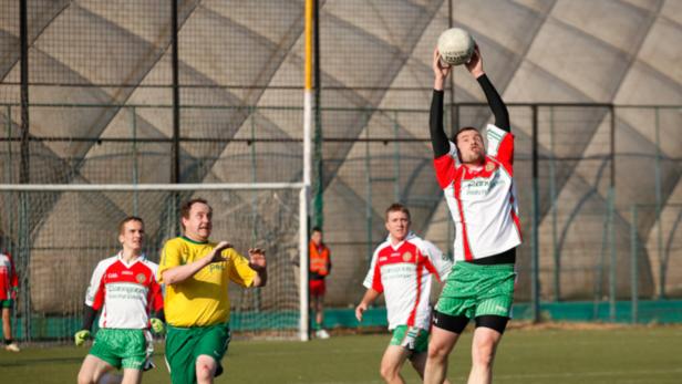 Ein Gaelic-Football-Spieler fängt einen Ball in der Luft.