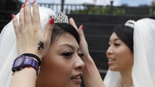 Eine Braut mit Diadem und Schleier wird für ihre Hochzeit vorbereitet.