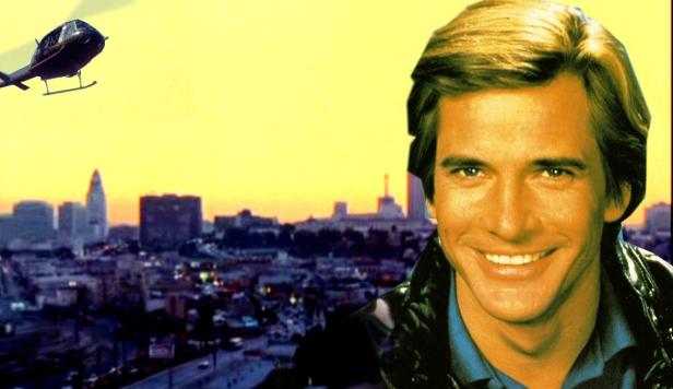 Ein lächelnder Mann vor der Skyline von Los Angeles mit einem Hubschrauber im Himmel.