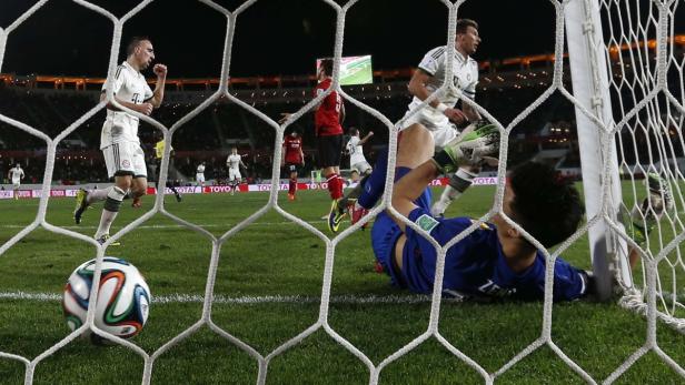Ein Fußballspiel mit einem Torwart am Boden und einem Fußball im Netz.