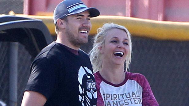 Britney Spears und ein Mann lachen zusammen.