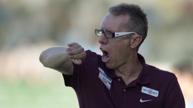 Ein Trainer gestikuliert und schreit während eines Spiels.