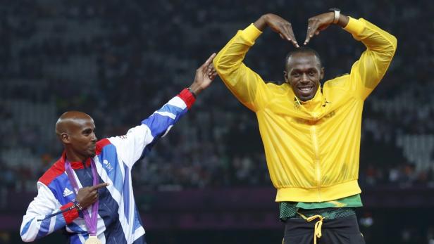Usain Bolt formt mit seinen Händen ein Herz, während Mo Farah auf ihn zeigt.