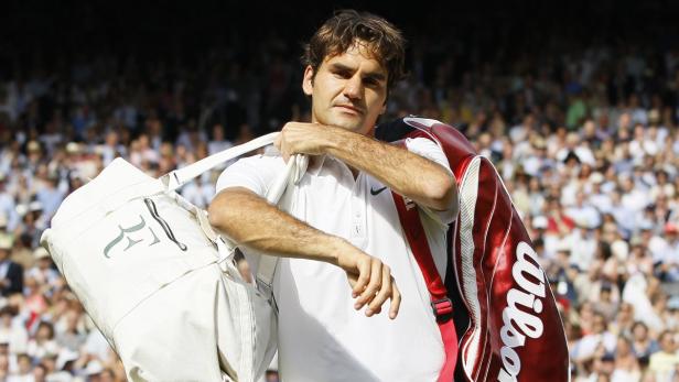 Roger Federer mit Tennistasche auf dem Platz vor einer Zuschauermenge.