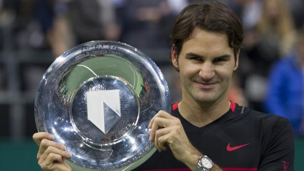 Roger Federer hält die ABN AMRO Trophäe in den Händen.