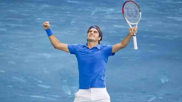 Roger Federer feiert mit erhobenen Armen und Tennisschläger einen Sieg.