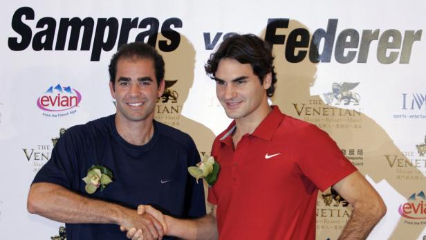 Pete Sampras und Roger Federer geben sich die Hand vor einem Sponsorenhintergrund.