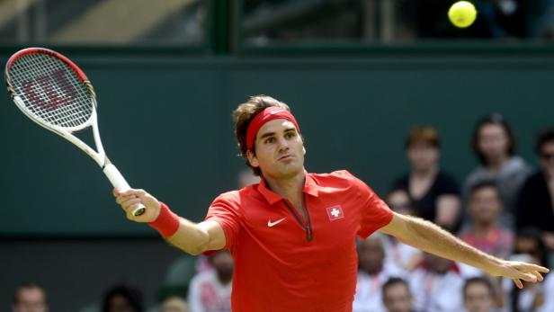 Roger Federer bei einem Tennisspiel in rotem Hemd und Stirnband.