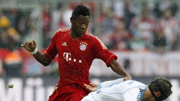 David Alaba vom FC Bayern München im Zweikampf während eines Fußballspiels im Regen.