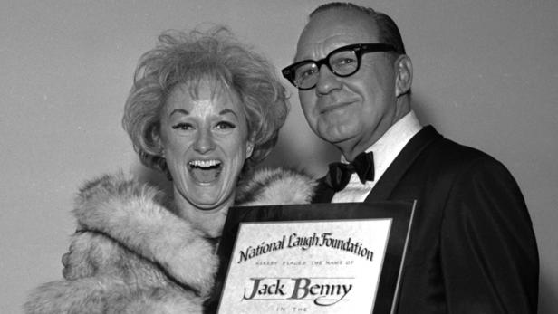 Jack Benny und eine Frau halten eine Auszeichnung der National Laugh Foundation.