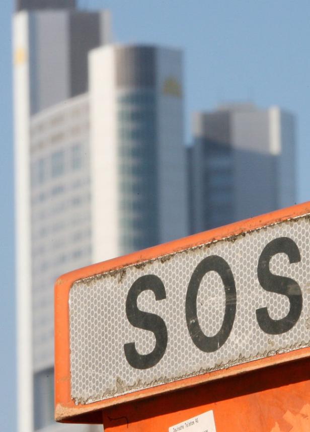 Ein orangefarbenes Schild mit der Aufschrift „SOS“ vor Hochhäusern.