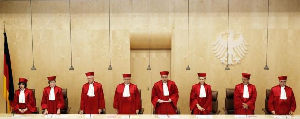 Acht Richter in roten Roben sitzen im Gerichtssaal des Bundesverfassungsgerichts.