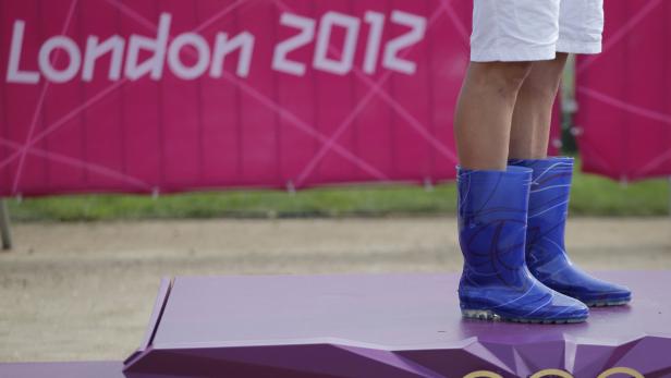 Stiefelkönig: Der tschechische Jaroslav Kulhavy tauchte bei der Siegerehrung mit blauen Gummistiefeln auf. Blaue Gummistiefel auf einem Podest vor einem „London 2012“-Banner.