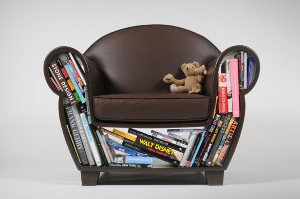 Ein brauner Sessel mit Büchern in den Armlehnen und einem Teddybär auf dem Sitz.