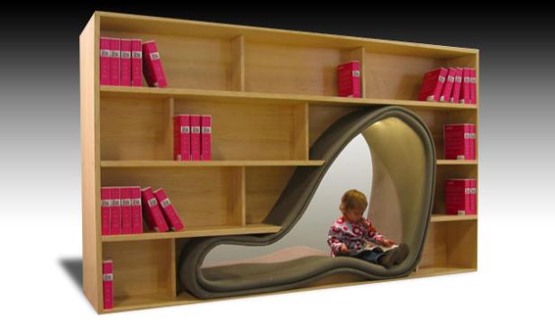 Ein Kind sitzt in einem Bücherregal mit integriertem Lesebereich und liest ein Buch.