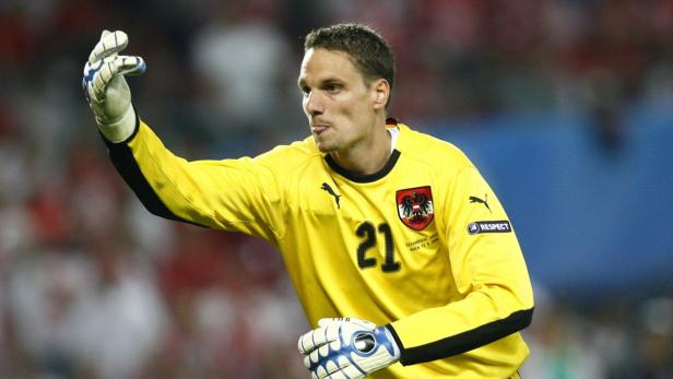 Ein österreichischer Fußballtorwart in gelbem Trikot mit der Nummer 21 während eines Spiels.