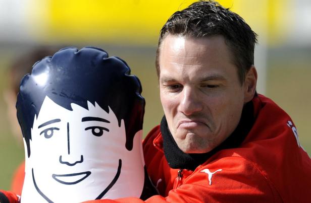 Ein Mann mit roter Jacke umarmt eine aufblasbare Puppe mit aufgemaltem Gesicht.