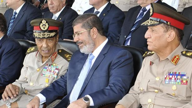 Präsident zeigt Muskeln: Feldmarschall Tantawi (li.) und Generalstabchef Sami Anan (re.) mussten gehen Der ehemalige ägyptische Präsident Mohammed Mursi mit zwei Militärangehörigen.