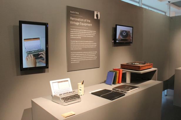 Eine Ausstellung mit einem modifizierten Laptop, einem Plattenspieler und einer Informationstafel von Austin Yang.