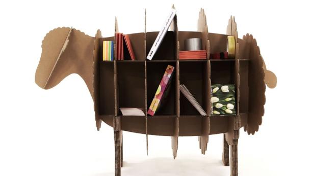 Ein Regal in Form eines Schafs, aus Karton gefertigt und mit Büchern und anderen Gegenständen gefüllt.