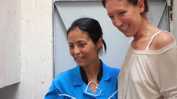 Zwei Frauen stehen lächelnd nebeneinander.