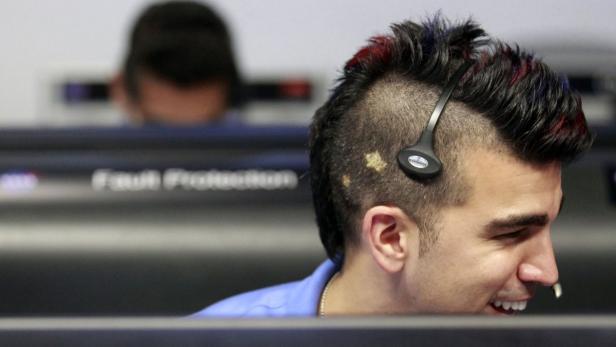 Ein Mann mit Headset und auffälliger Frisur arbeitet an einem Computer.