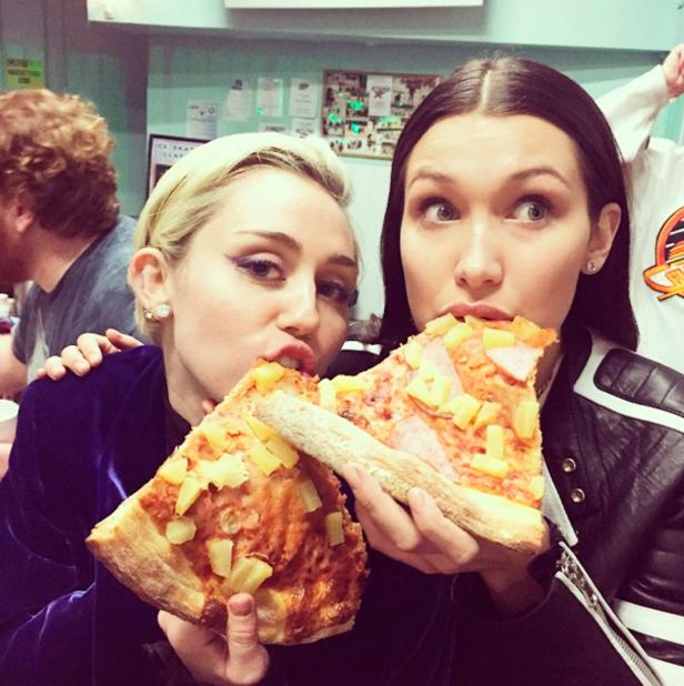 Miley Cyrus und Bella Hadid essen Pizza mit Ananas.