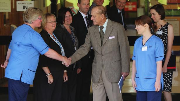Prinz Philip schüttelt einer Krankenschwester die Hand vor einem Krankenhaus.