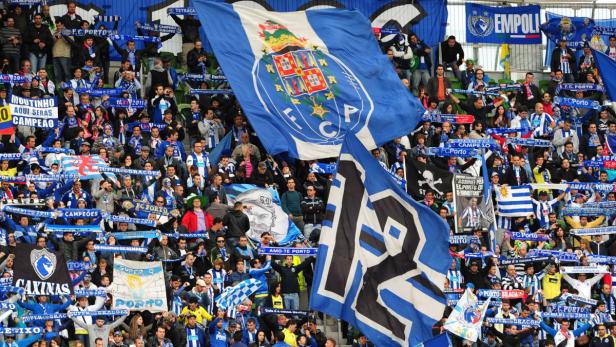 Eine Menschenmenge schwenkt Fahnen und Schals des FC Porto in einem Stadion.