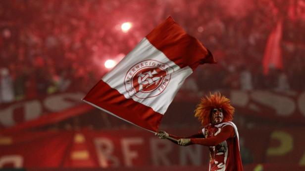 Ein Fan schwenkt eine rot-weiße Flagge des Sport Club Internacional im Stadion.