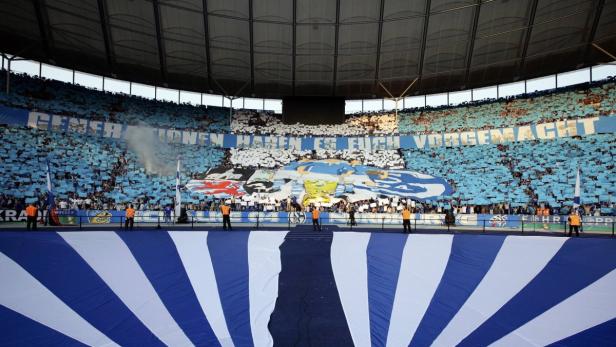 Fans von Schalke 04 zünden Pyrotechnik und zeigen eine große Blockfahne im Stadion.