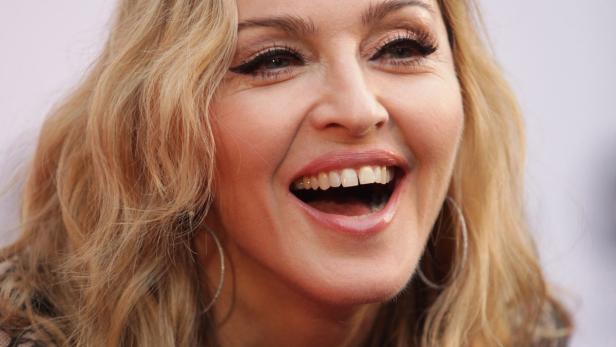 Nahaufnahme von Madonna, die lacht und Ohrringe trägt.