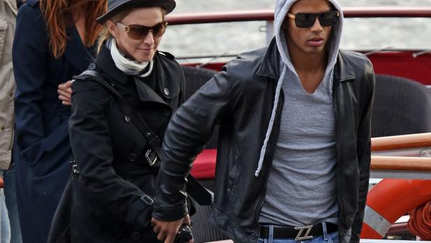 Madonna mit ihrem Freund auf einem Boot, beide tragen Sonnenbrillen und dunkle Jacken.