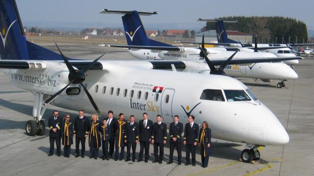 Das Personal von InterSky posiert vor mehreren Flugzeugen der Fluggesellschaft.